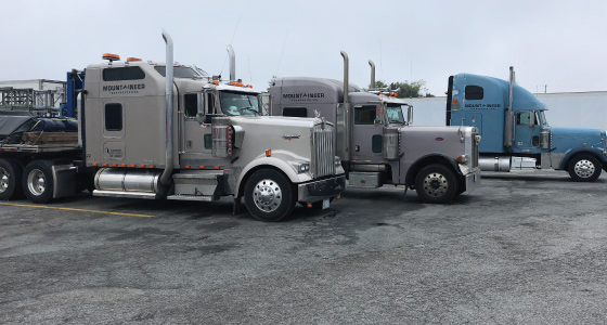 Three flatbed carrier trucks side by side Three flatbed carrier trucks side by side